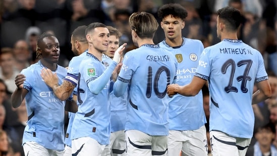 Manchester City's Belgian midfielder #11 Jeremy Doku (L) celebrates scoring the team's first goal during the English League Cup third round(AFP)